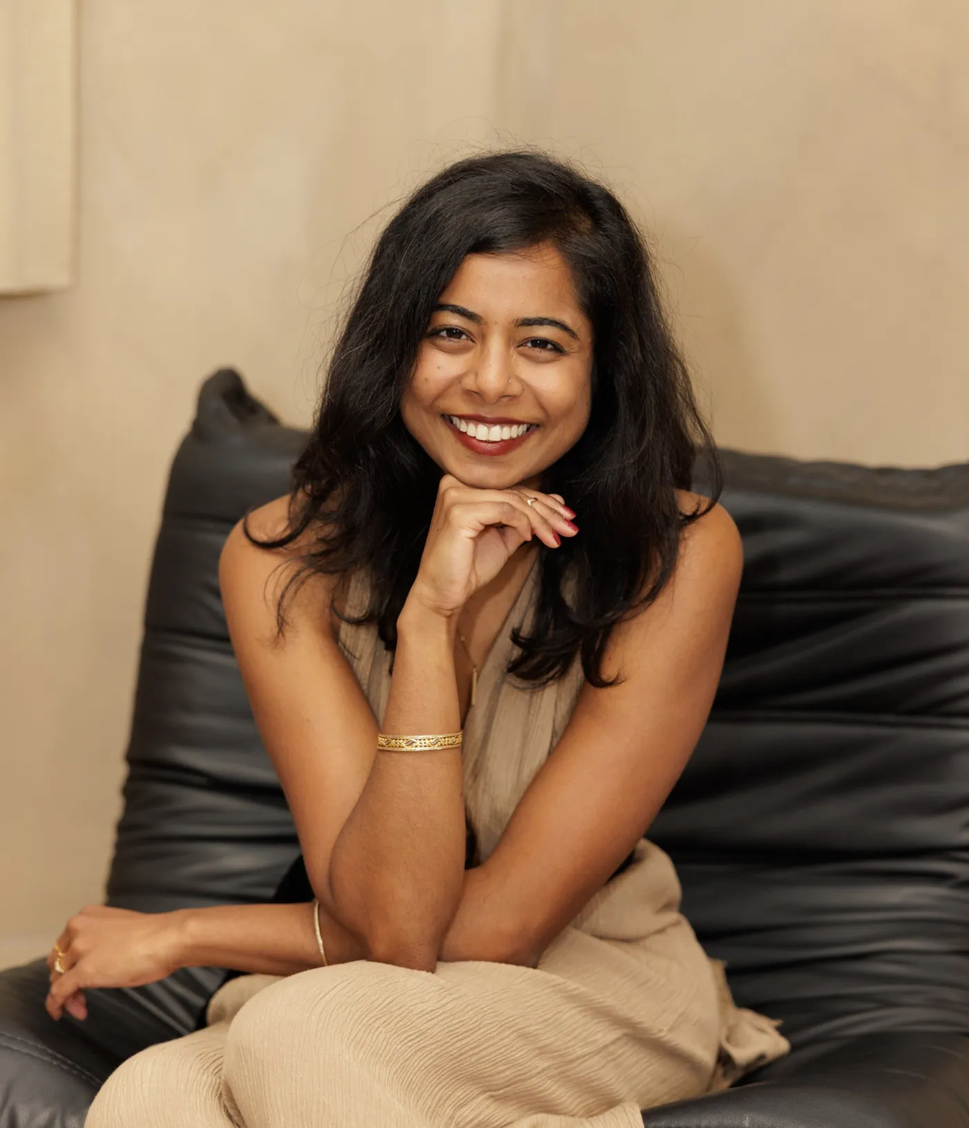 Naba Ahsan, smiling, seated with her chin resting on her hand